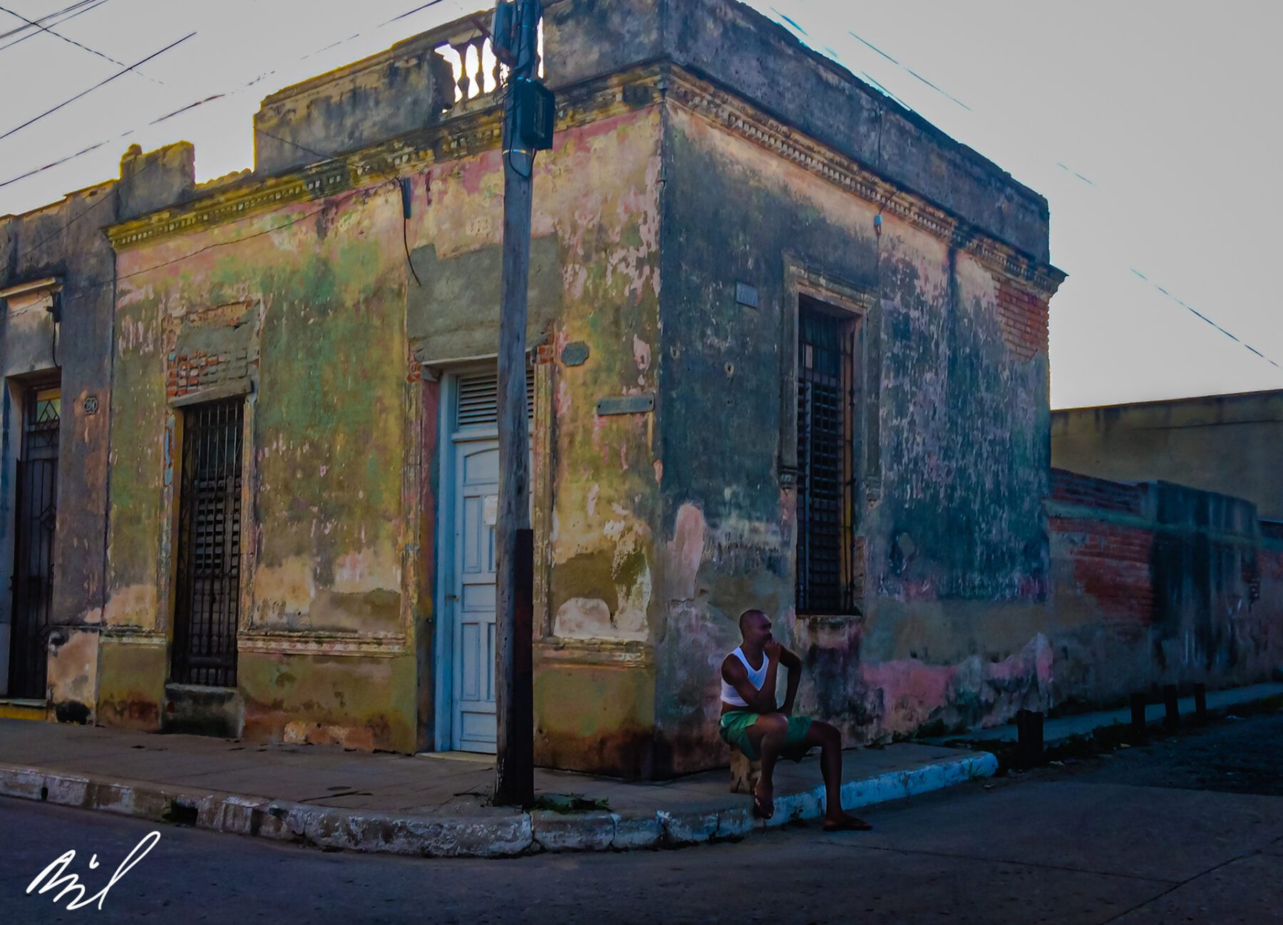 A man sitting on a bench in front of Cuba.