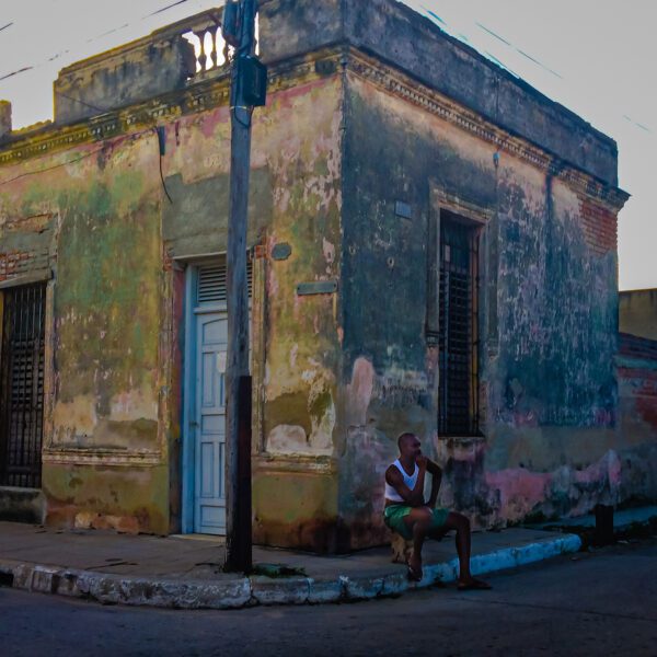 A man sitting on a bench in front of Cuba.