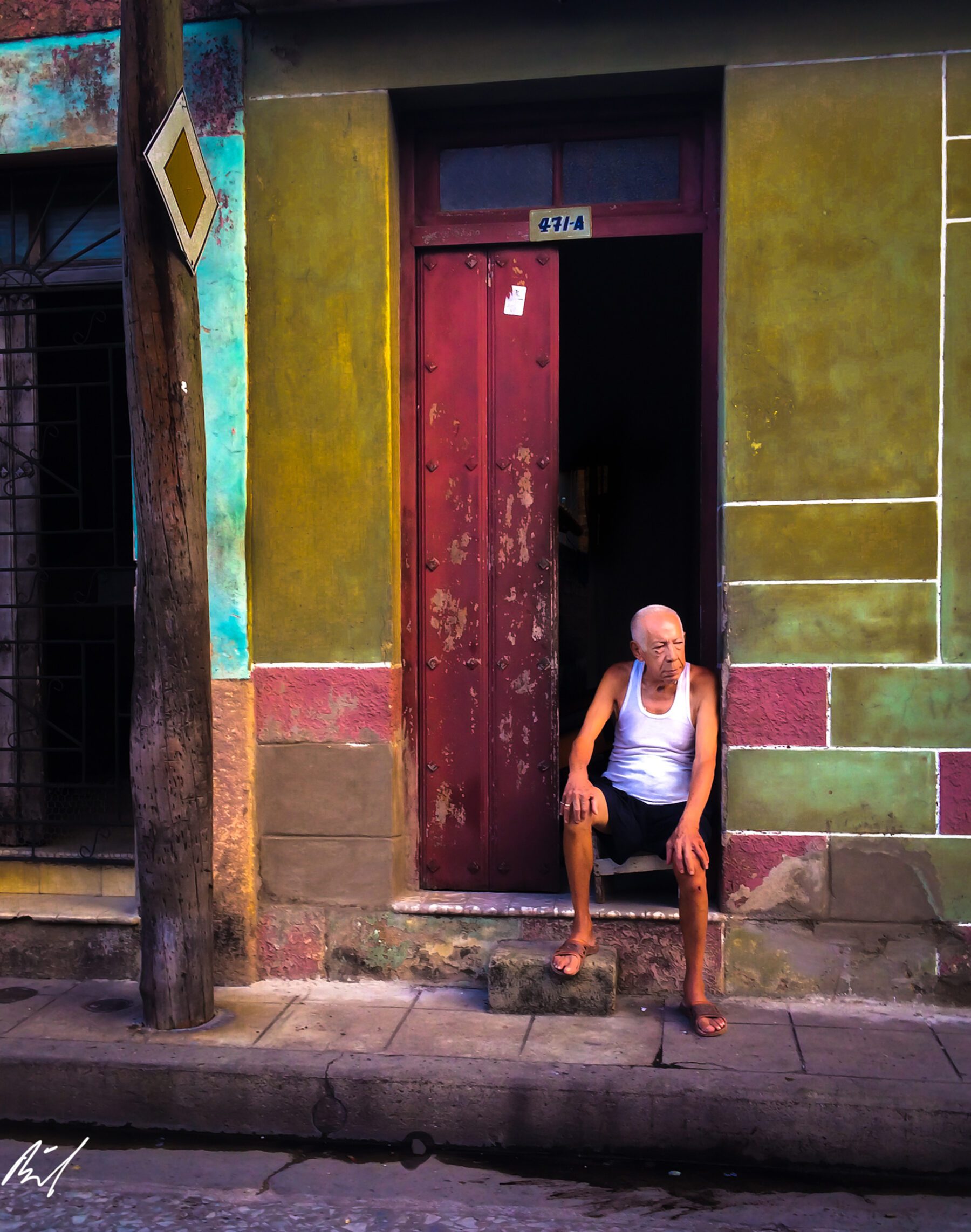 An old man sitting on the steps of Cuba.