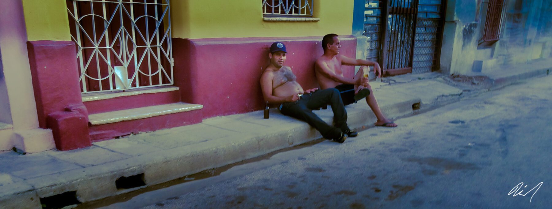 Two men sitting on the side of Cuba.