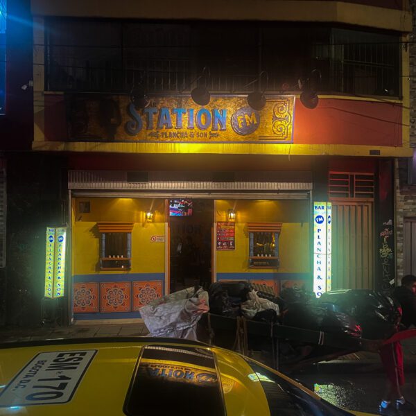 A taxi parked in front of a restaurant at night.