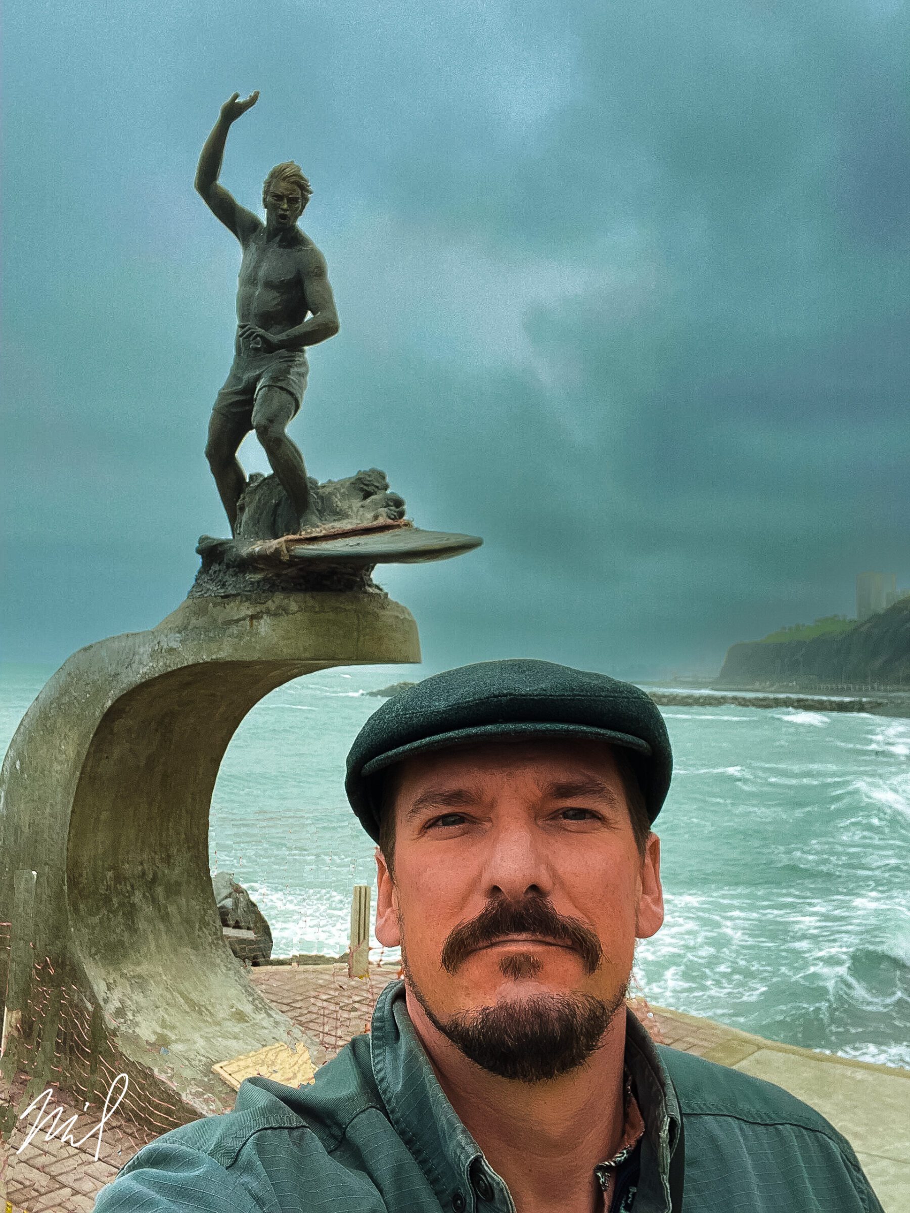A man is taking a selfie in front of a statue of Peru.