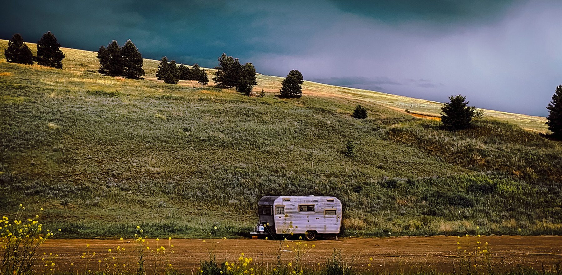 A Montana sits on a hill under a stormy sky.